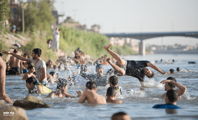 Young men having fun in Tigris River on a hot day by Ziyad.matti
