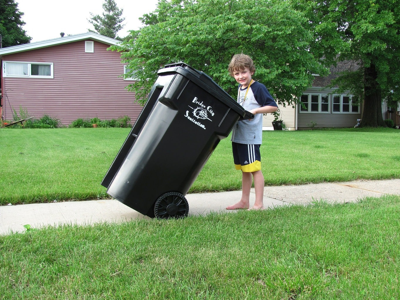 a boy holding recycling bin