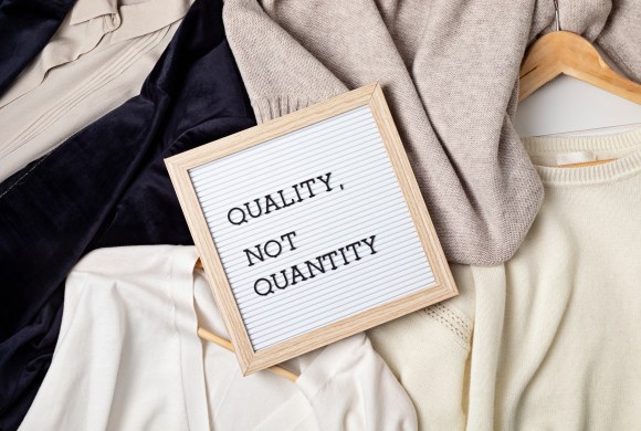 Flat lay of clothes and hangers; assortment of women's clothing. Second hand sustainable shopping; capsule minimal wardrobe; slow fashion idea; quality not quantity concept for your wardrobe