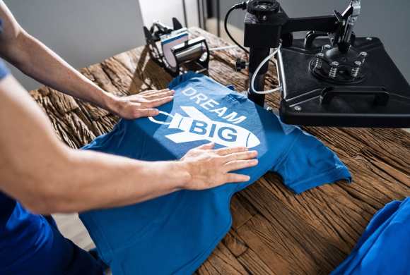 Man Printing On T Shirt In Workshop