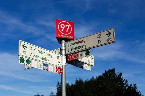 a street sign on a pole in front of a blue sky germans