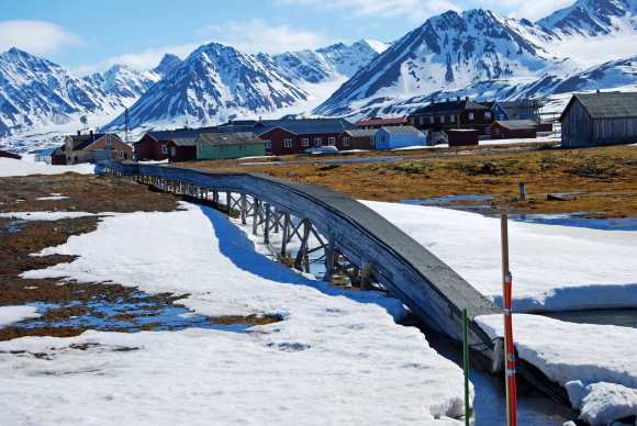 Ny-Ålesund is one of the four permanent settlements on the island of Spitsbergen in the Svalbard archipelago  /  a winter bridge (Wikimedia COmmons)